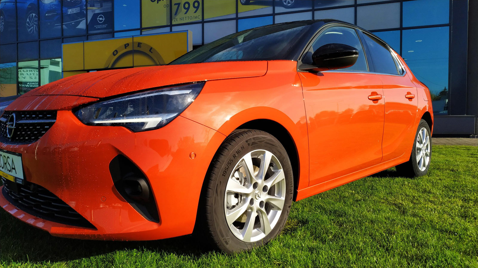 Pomarańczowa nowa Corsa F przed salonem Opel