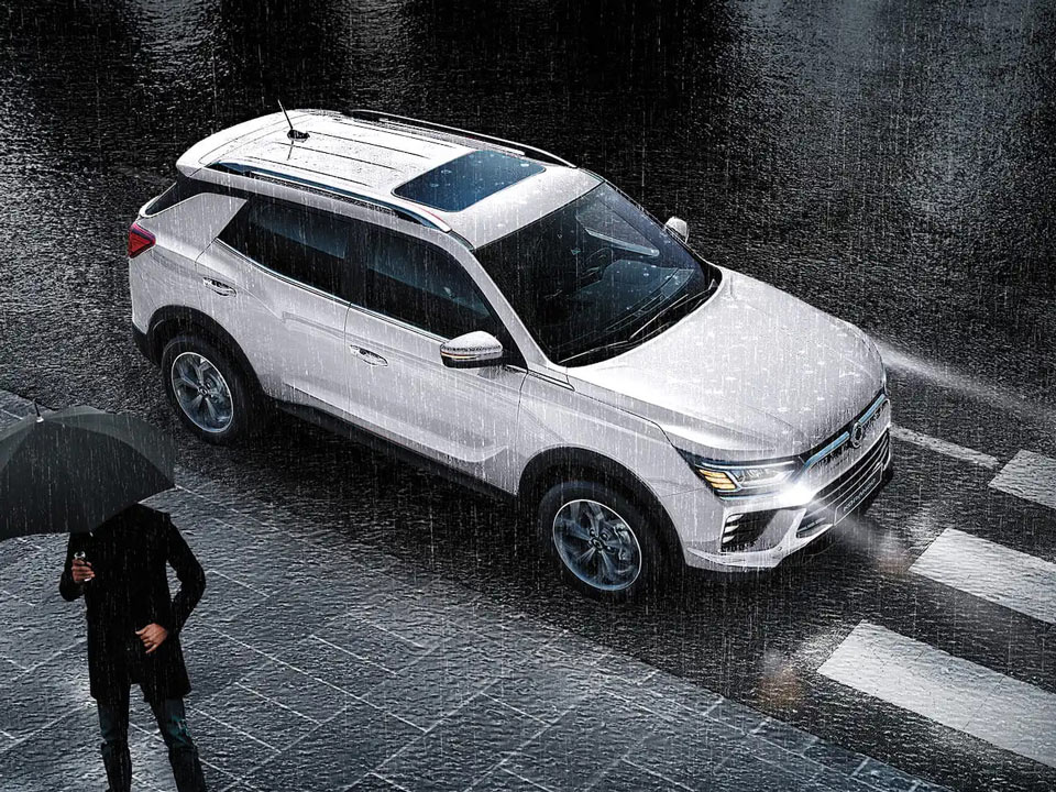 KGM Korando, jazda w deszczu. Noc, przejście dla pieszych, pieszy z parasolem