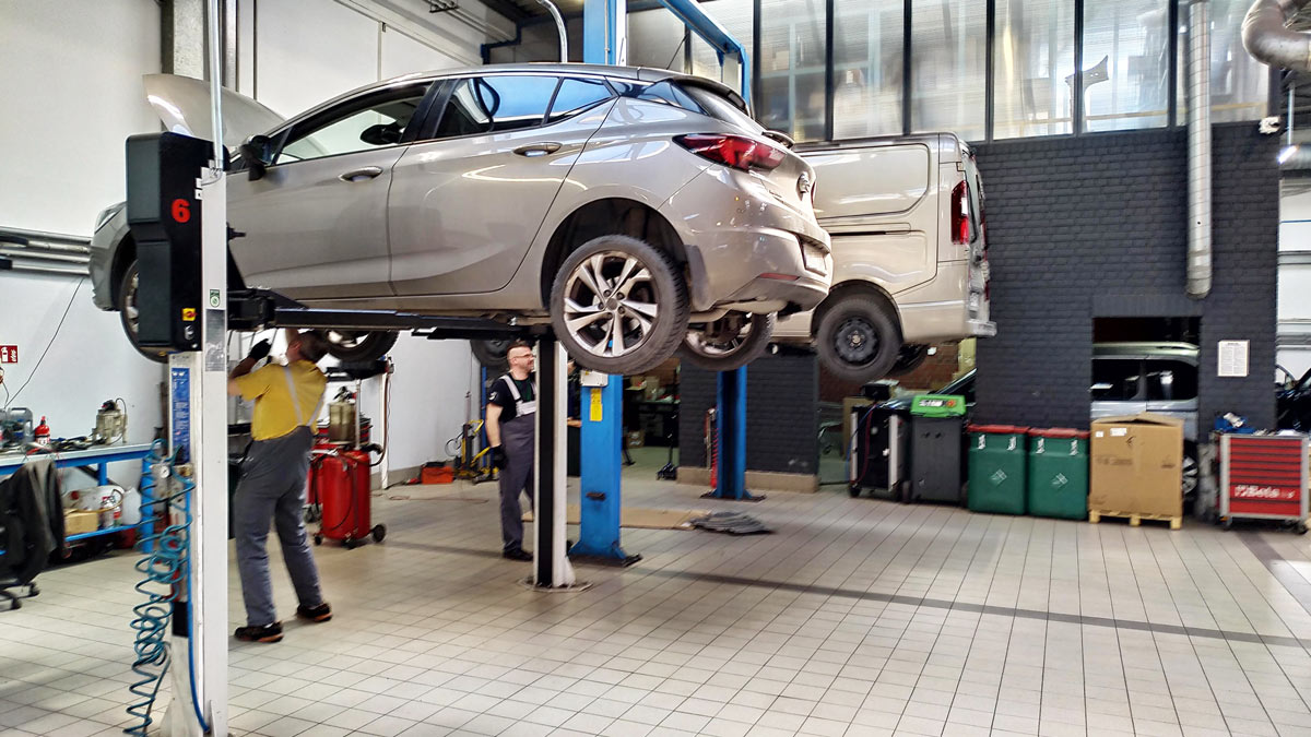 Opel Astra V w serwisie na podnośniku, mechanicy