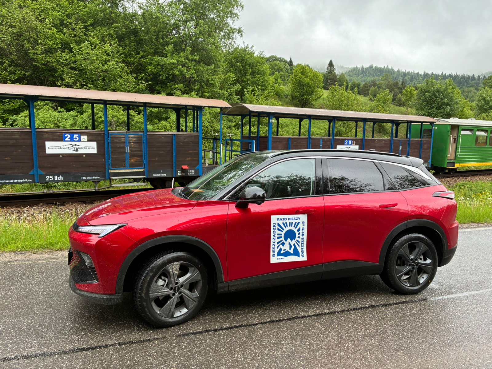 BAIC 5 i wagony letniaki oraz osobowy Bieszczadzkiej Kolei Wąskotorowej. Naklejka na drzwiach samochodu Bieszczadzki Rajd Pieszy
