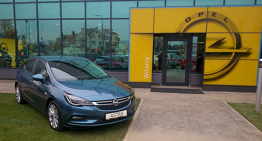 Granatowa metalik Astra V przed wejściem do salonu Opel